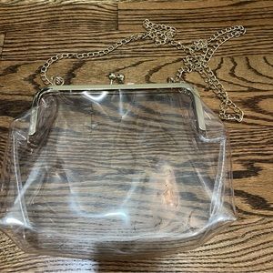 Clear bag with gold chain strap.